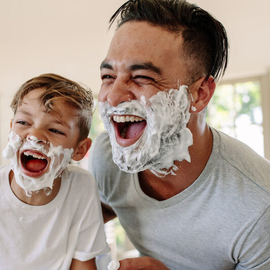 Dad and son having fun while shaving in bathroom coparenting 